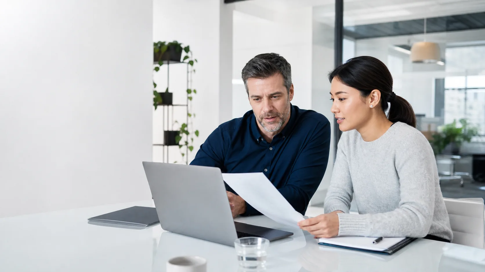Business consultant reviewing a staffing plan with a client in a bright office